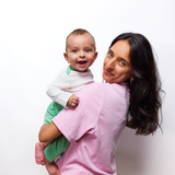 Adult Solid Tshirt Pink holding Baby in Long Sleeve bodysuit and green jogger pants