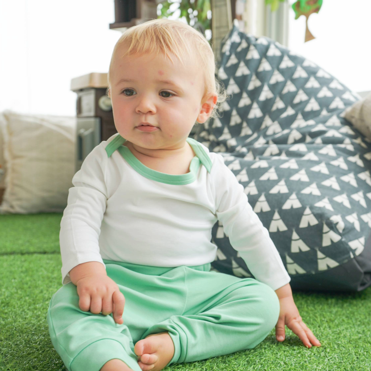 Baby wearing the grass green Baby Essentials Bundle outfit set with Peruvian Pima cotton onesie and jogger pants
