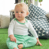 Baby wearing the grass green Baby Essentials Bundle outfit set with Peruvian Pima cotton onesie and jogger pants
