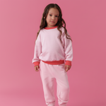 Pink | Young girl wearing a pink outfit on a pink background