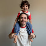 White with Engine Red | Man carrying a child on his shoulders indoors