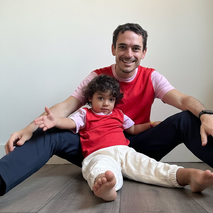 Engine Red with Pink | Man and child sitting on the floor wearing matching red shirts against a plain background