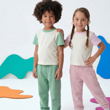 Grass Green; Pink | Two children wearing matching outfits with colorful abstract shapes in the background