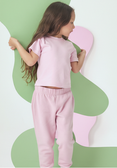 Pink | Child wearing a light pink outfit on a white background