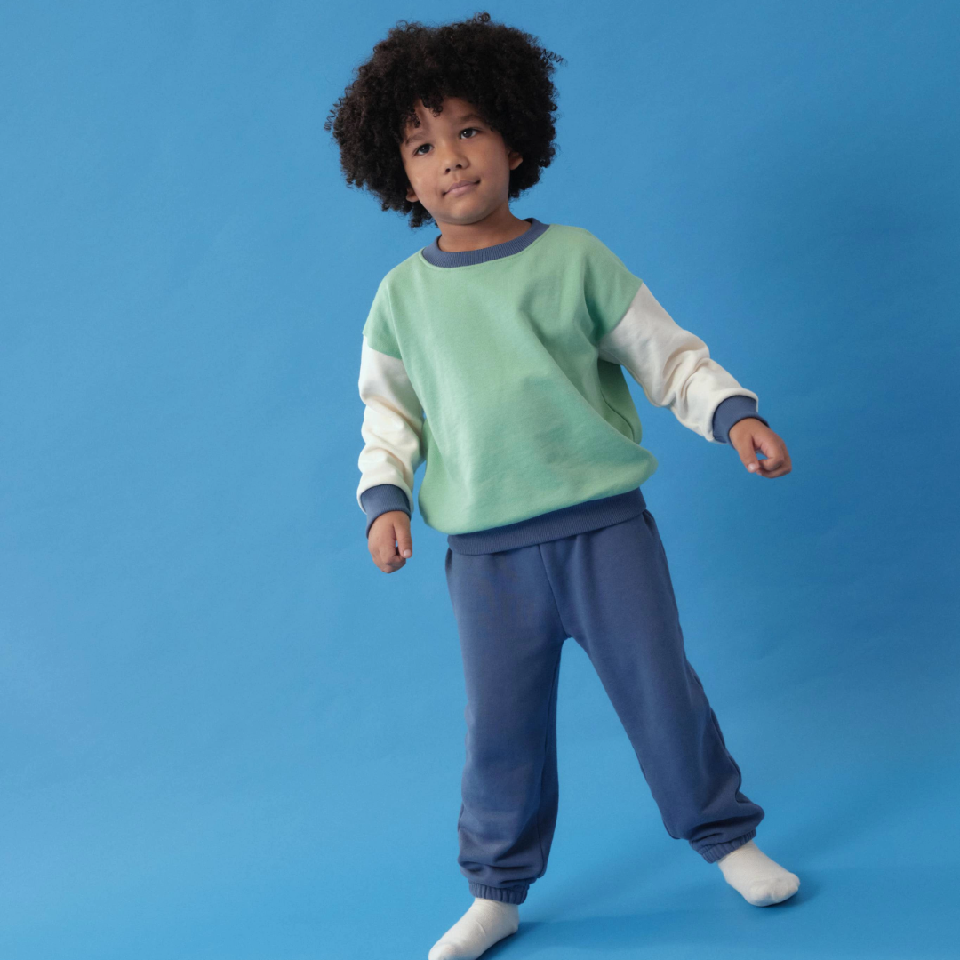 Toddler wearing Arquia Green Trio sweatshirt and french terry sweatpants in navy blue