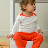 Baby wearing long sleeve bodysuit and jogger pants in white with red made of 100% peruvian pima cotton