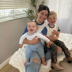 White with Navy Blue | Woman sitting on a couch with two children, smiling at the camera with matching clothes