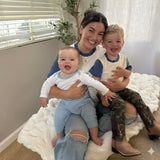 White with Light Blue | Woman sitting on a couch with two children, smiling at the camera with matching clothes