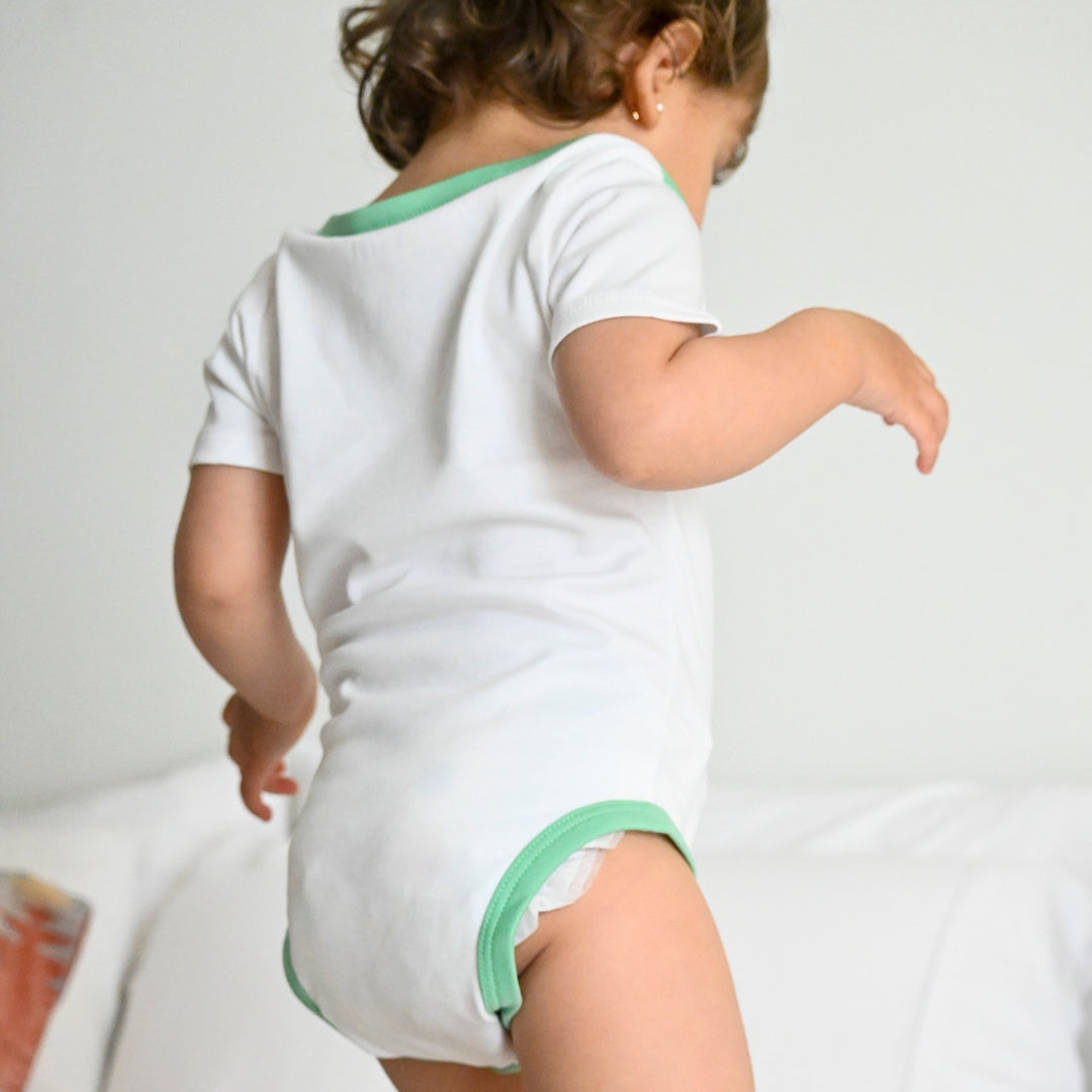 White with Grass Green | Baby wearing Short sleeve baby onesie in Peruvian Pima cotton from the Baby Essentials Bundle