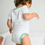 White with Grass Green | Baby wearing Short sleeve baby onesie in Peruvian Pima cotton from the Baby Essentials Bundle