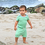 Baby wearing Sunny Day Set: short sleeve bodysuit in green with blue and green shorts made of 100% peruvian pima cotton