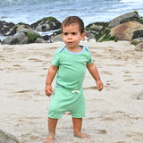 Baby wearing Sunny Day Set: short sleeve bodysuit in green with blue and green shorts made of 100% peruvian pima cotton